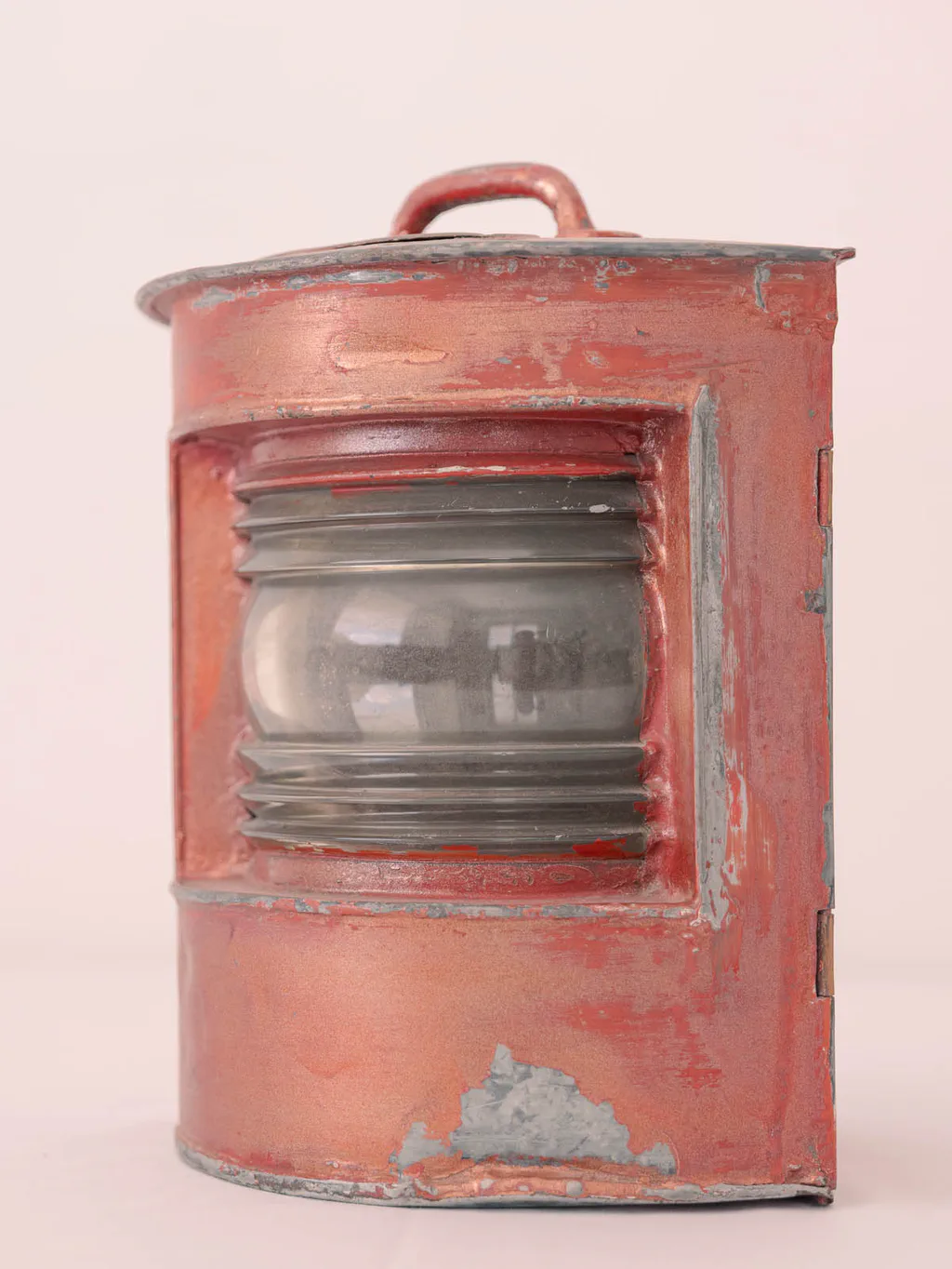 Pink-painted ship’s lantern, its glass lens clouded