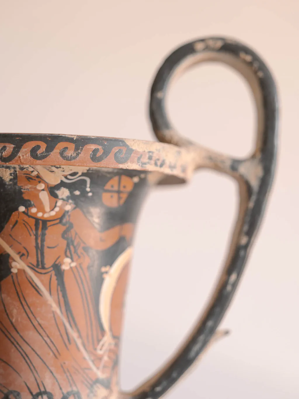 Handle of a red-figure Greek vase, a painted figure below it