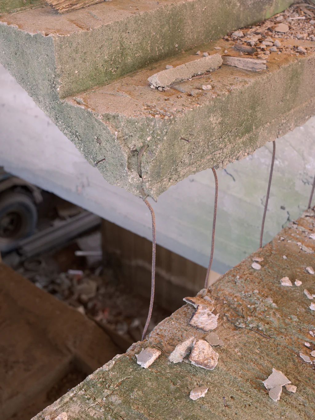 Unfinished staircase seen from below, exposed reinforcement and rubble