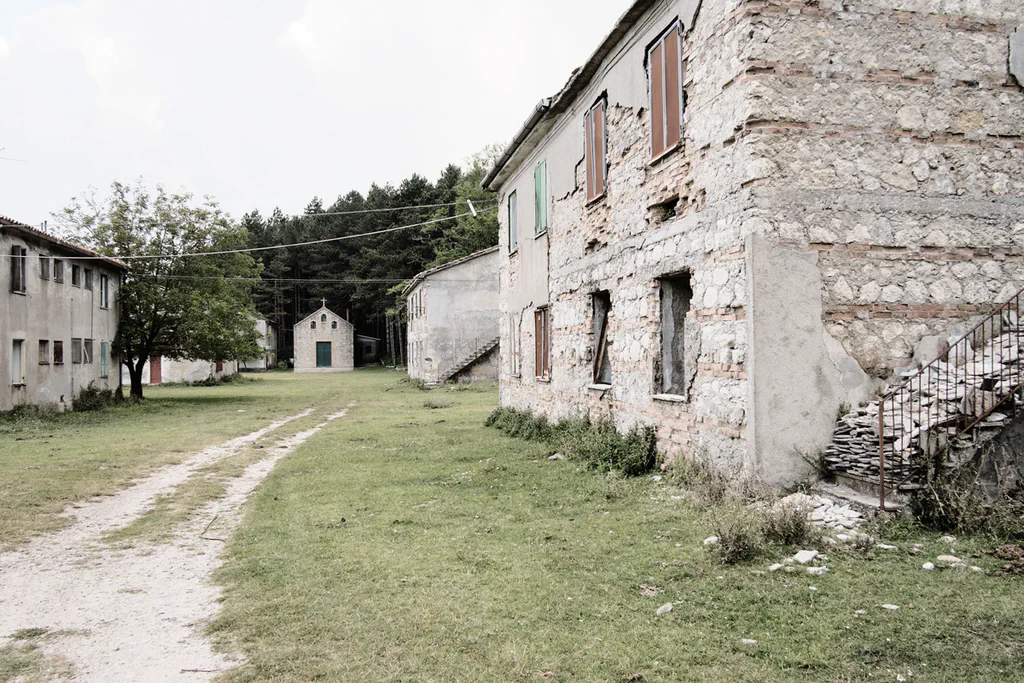 Dirt track between derelict stone buildings