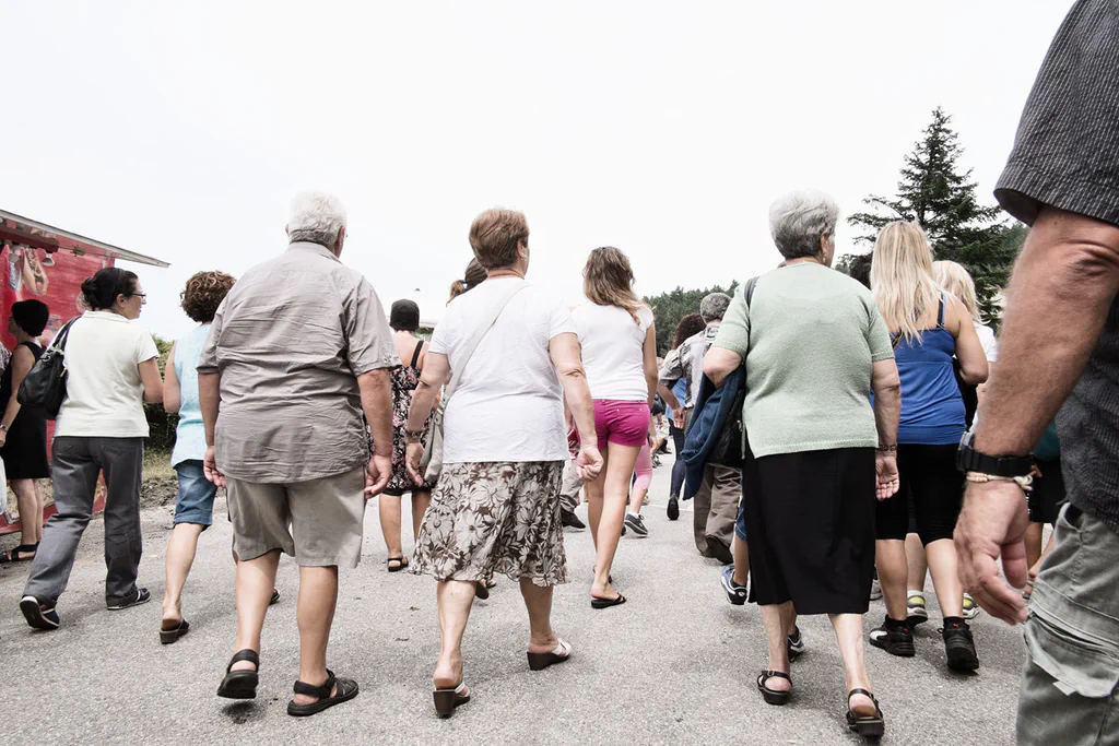 People walking together along a road, seen from behind