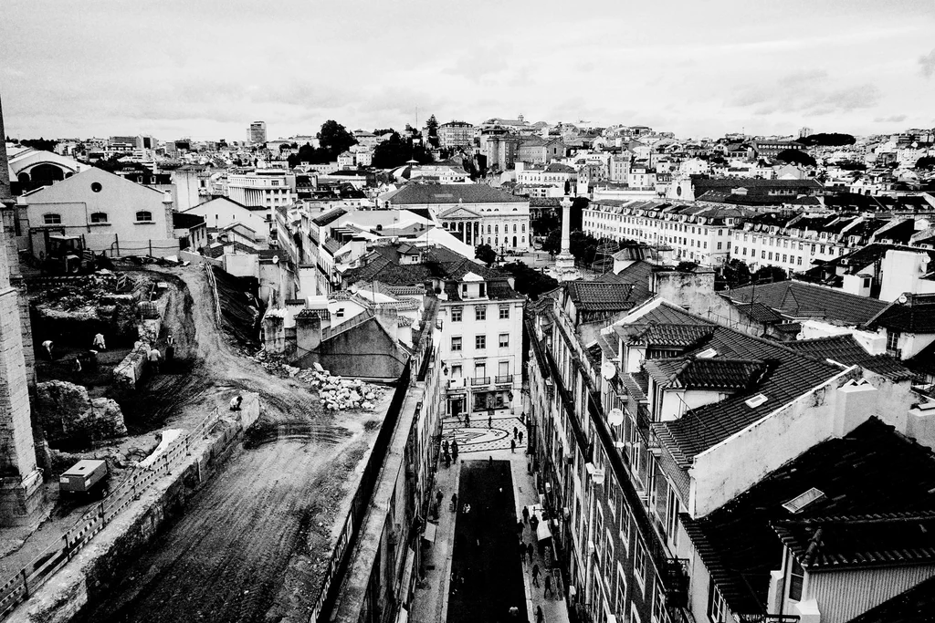 Rooftops of the city seen from above, a street running down towards the river