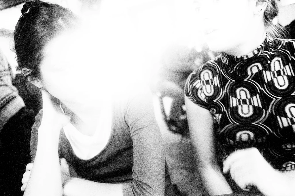 Two women at a market stall, the light burning out between them