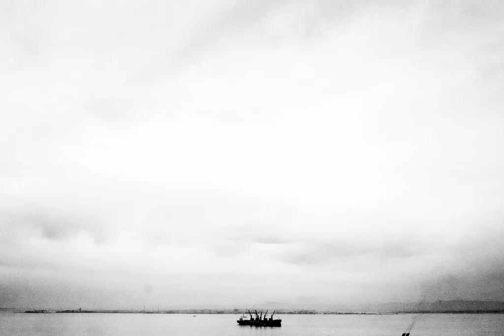 Boat on the river under a wide pale sky