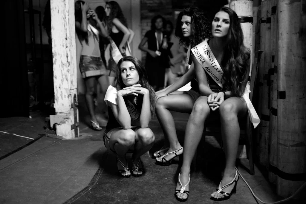 Contestants waiting in the wings, one crouching on the floor