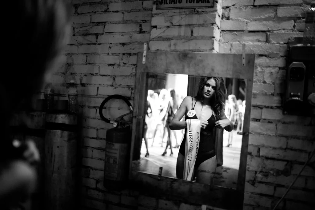 Contestant reflected in a mirror propped against a brick wall