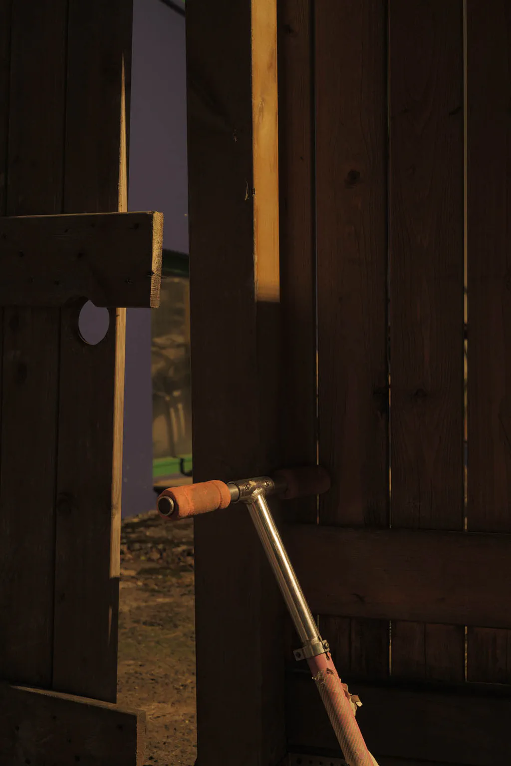 Garden hose reel against a dark wooden fence