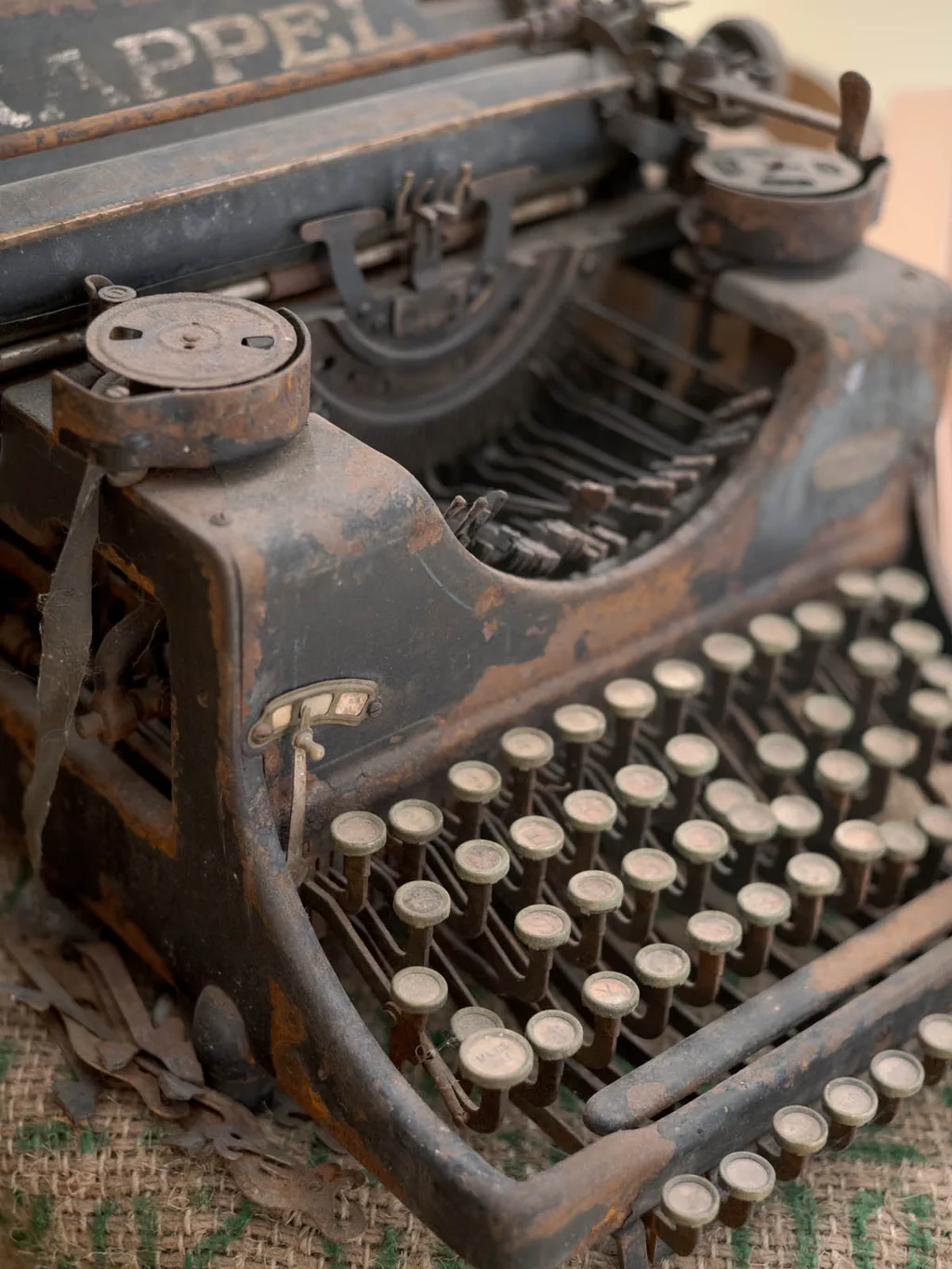 Antique typewriter with round keys, its maker’s name across the frame