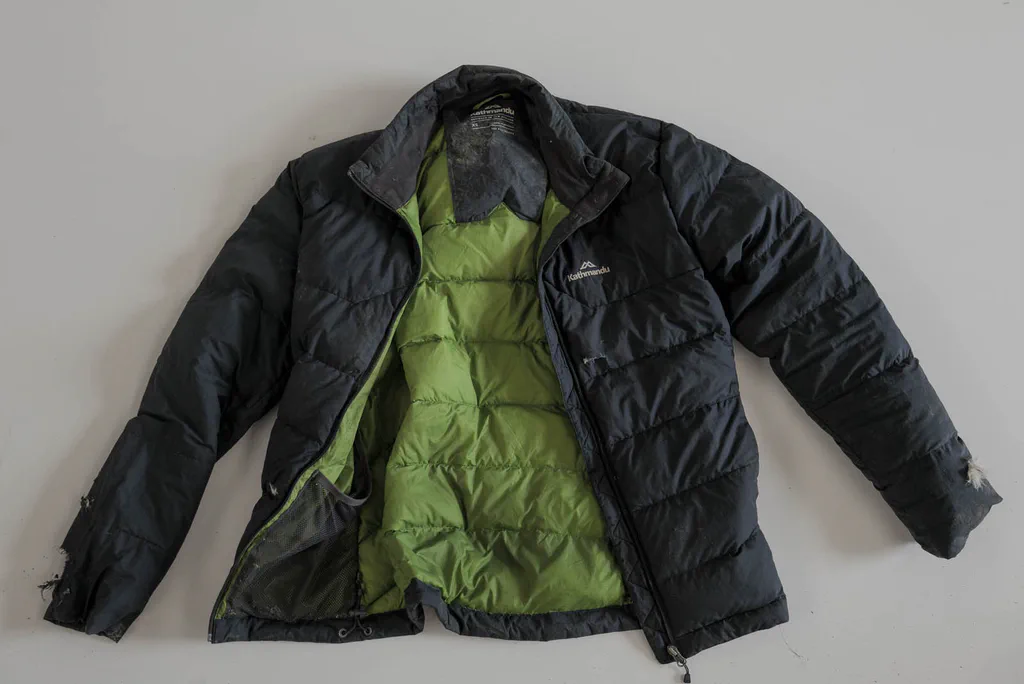 Black padded jacket with a green lining, laid open