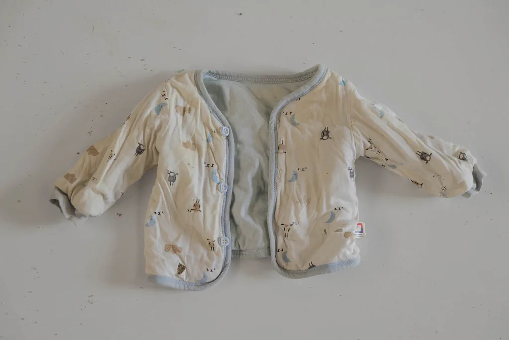 Infant’s cream jacket with a printed pattern