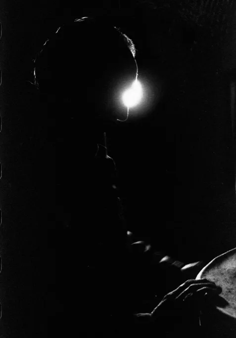 Profile of a man in darkness, a single light behind his head