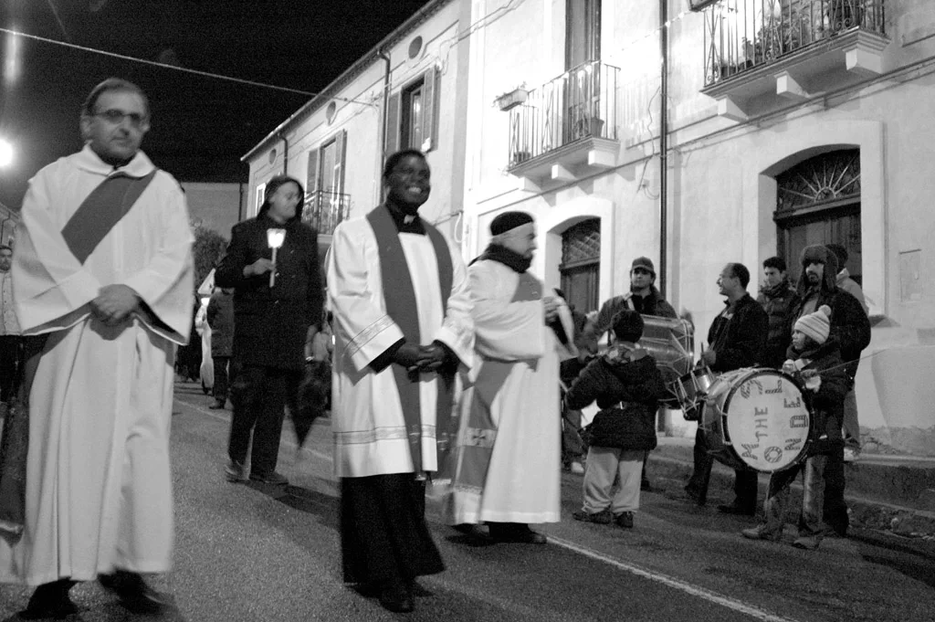 Priests in vestments leading a procession, drummers following