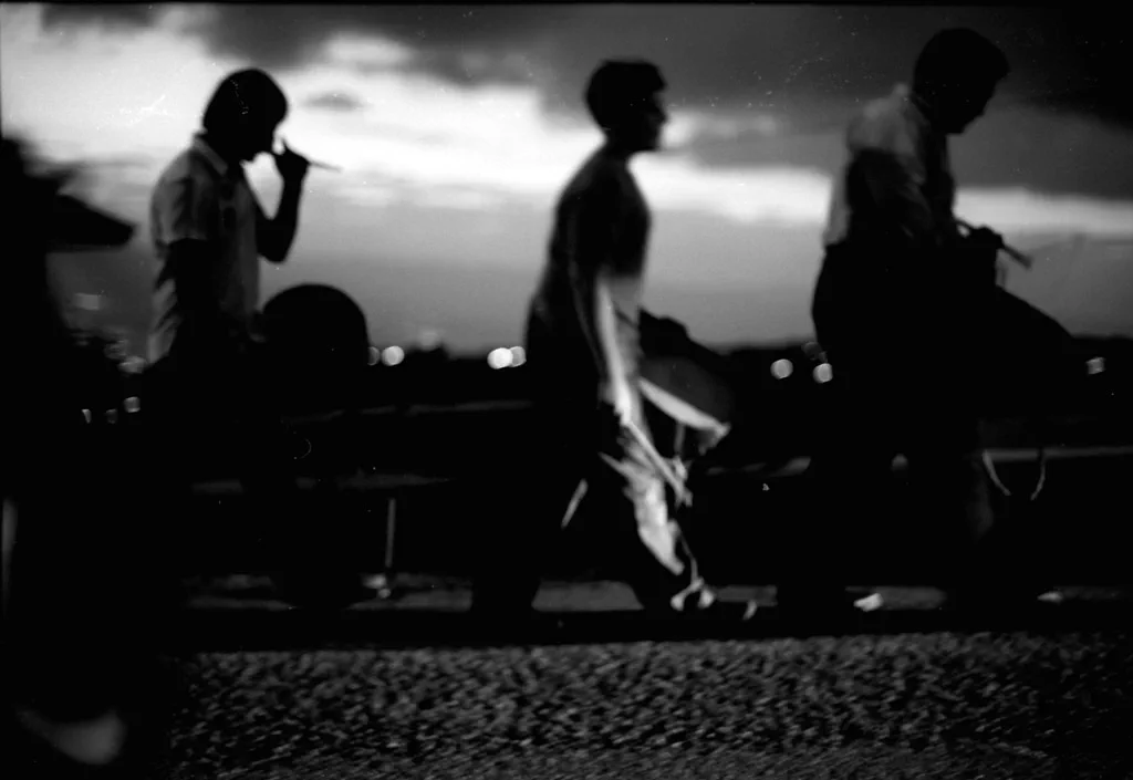 Figures silhouetted against the sky along a low wall