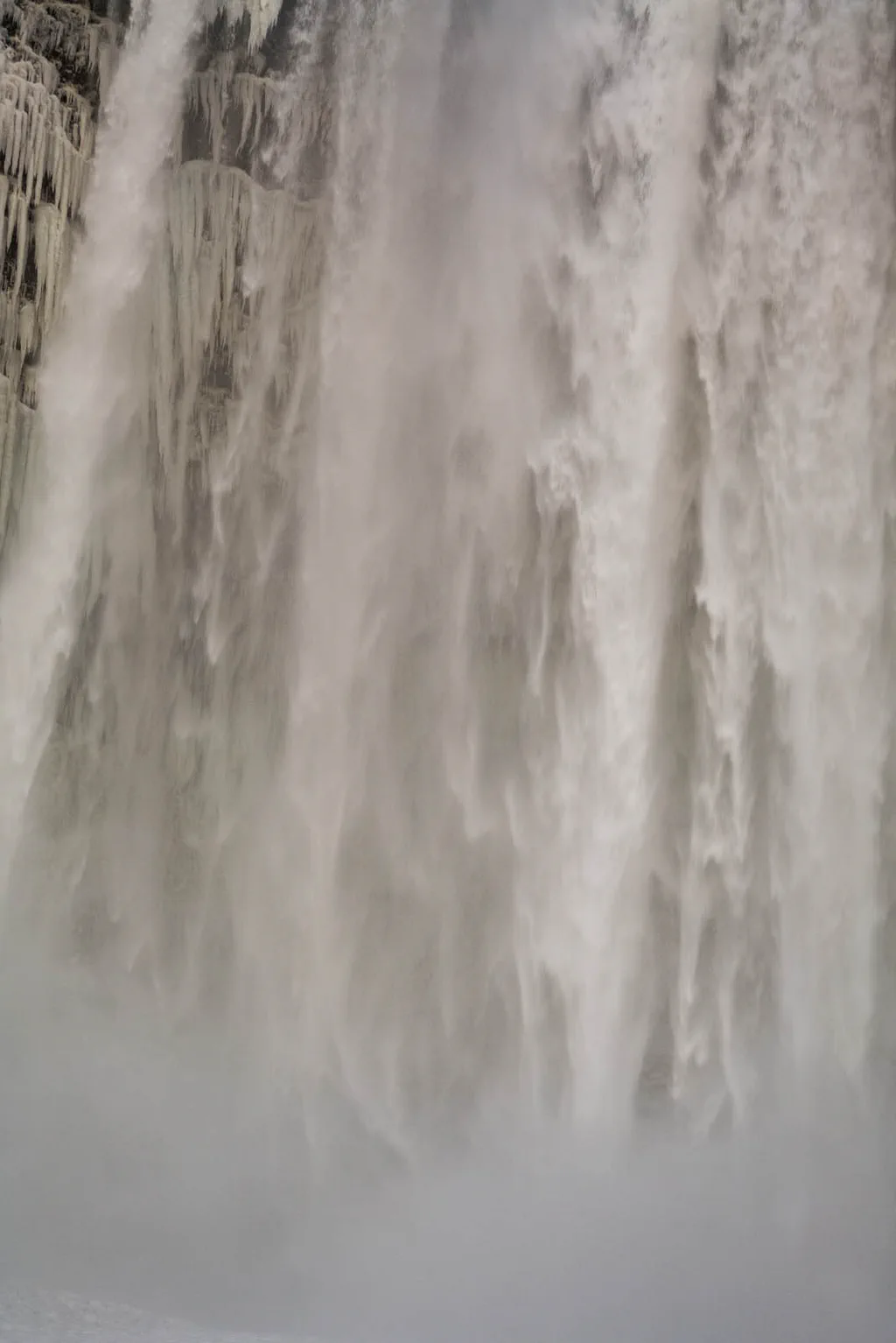Waterfall breaking into spray against a basalt wall