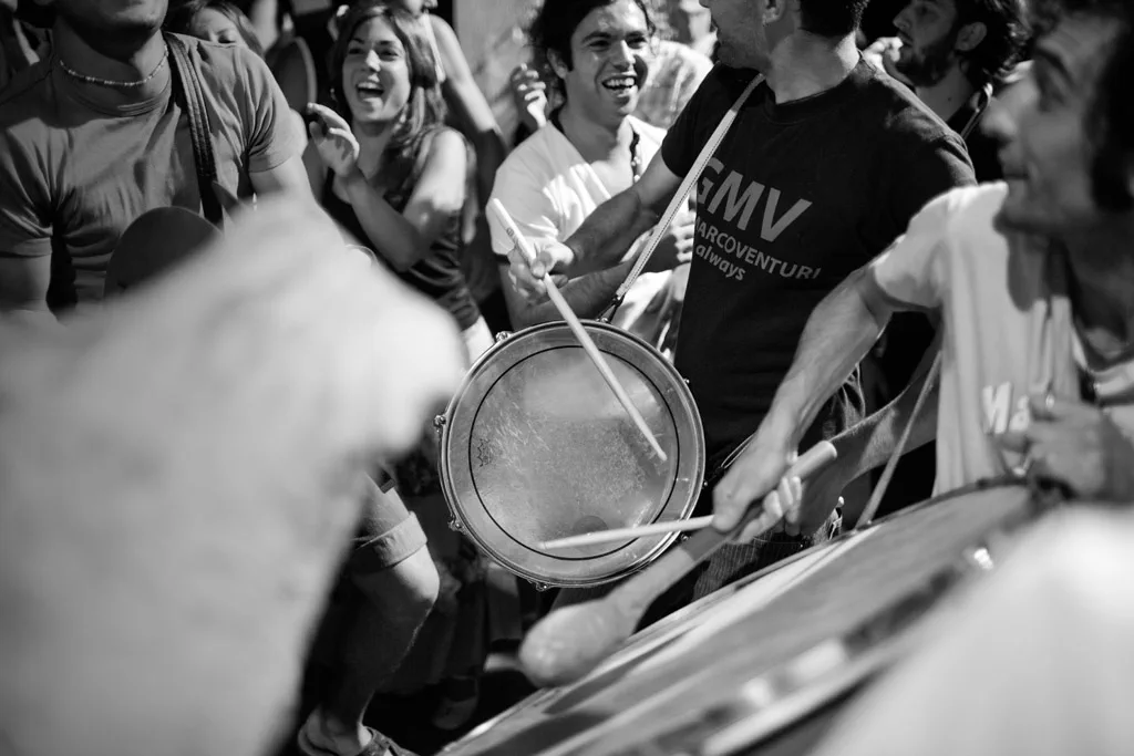 Frame drums held up in a dancing crowd