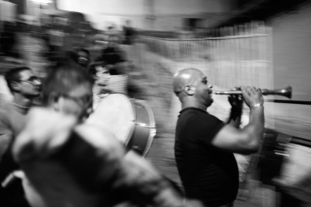 Musicians moving through a street, the picture blurred by their motion