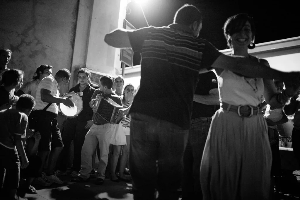 Dancers under a bright light in a crowded room