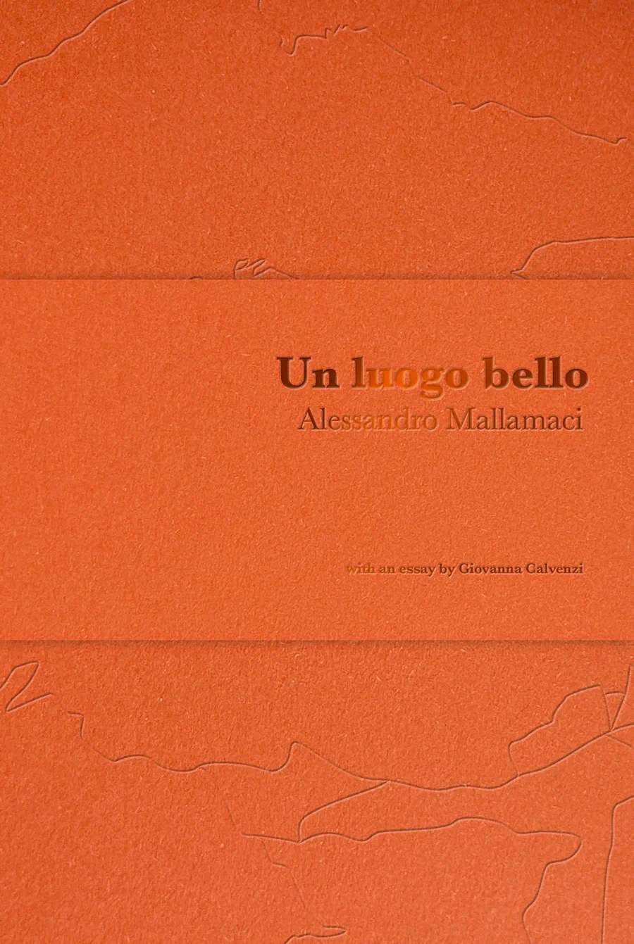 The cover of Un luogo bello: orange Fedrigoni Materica board with a blind-stamped title